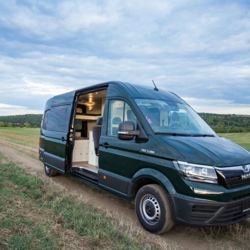 Der MAN TGE Camper in der Farbe Marinegrün auf einem Feldweg in Erfurt